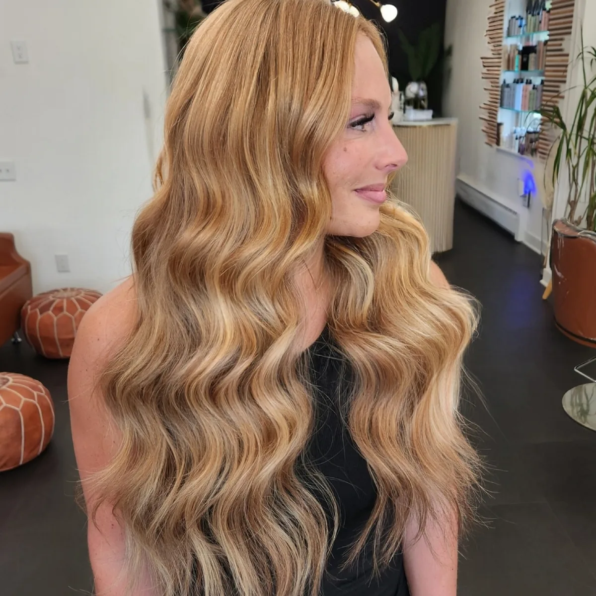 Honey blonde hand tied extensions styled into deep waves, photographed on the salon floor.