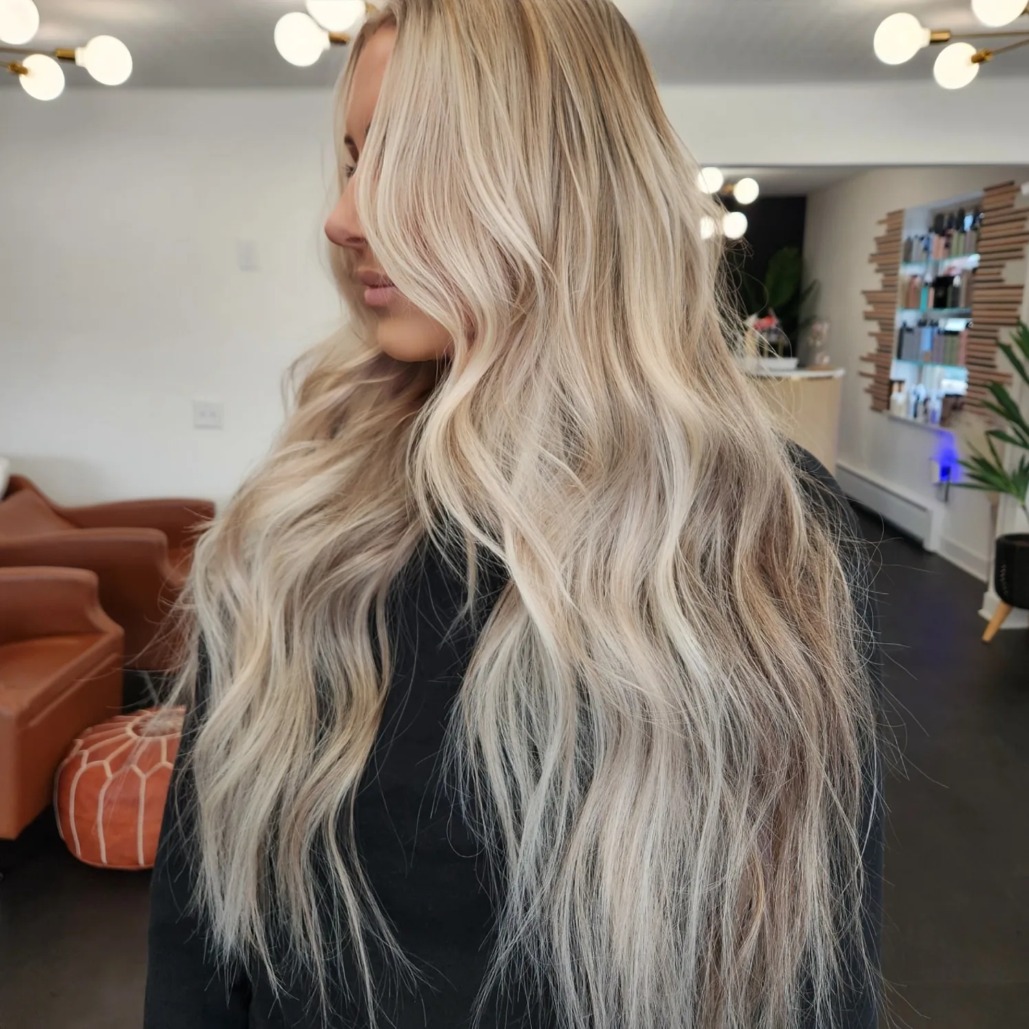 Platinum blonde extensions seen from behind, blended from a darker root into a bright cool end.